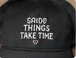 Black cap embroidered with 'Good things take time'